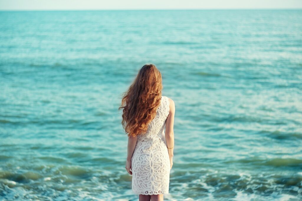 Beautiful woman with red hair at the sea